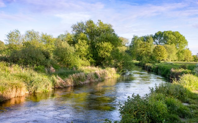 A river flowing through countryside on a sunny day
