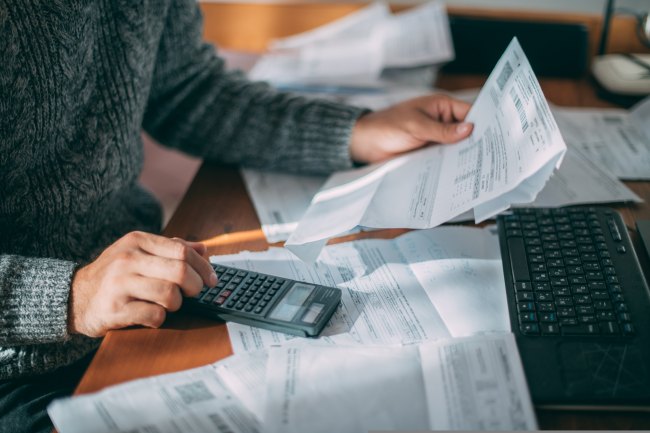 A person holding paper invoices