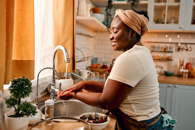Woman washing hands under tap